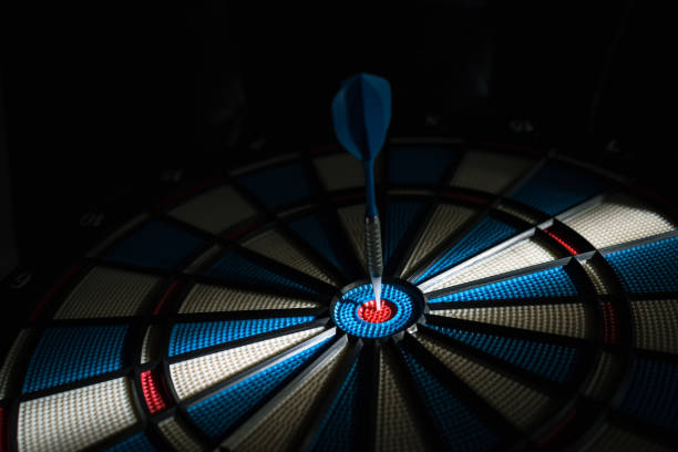 istock A dart hitting the center of target with copy space in dramatic light and shadow. Bullseye target or a dart dashboard for financial business planning and targeting with winner goal concept 1413776627