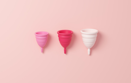 Copa menstrual en tres tamaños diferentes aislada sobre un fondo rosa. Cero residuos, alternativas ecológicas y reutilizables para el concepto de higiene menstrual y femenina en ilustración 3D photo