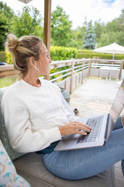 young woman working from home on her porch - france holiday villa built structure vertical imagens e fotografias de stock