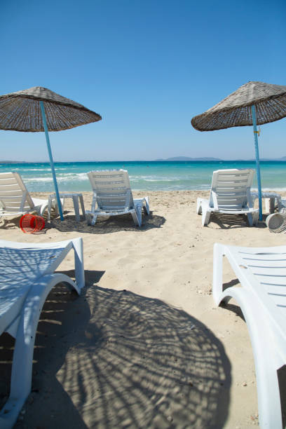 istock Lounge Chairs and Umbrella at the Beach 1413777244