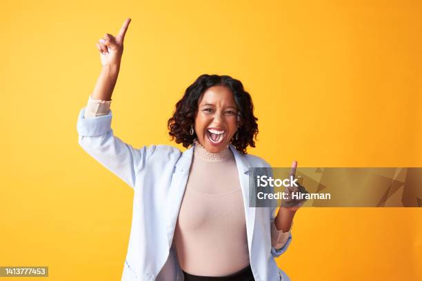 A Joyful Cheerful And Funny Woman Dancing Against A Bright Orange Background Portrait Of An Excited Fun And Playful Female Cheering With Fingers Pointing Up Dance Happy Woman Doing Winner Gesture Stock Photo - Download Image Now