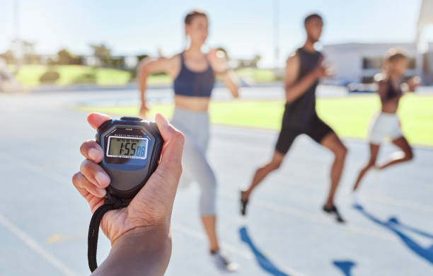 A sport coach timing athletes progress using a stopwatch.
Blurred athletes racing towards finish line and breaking the record. Stopwatch measuring time for a marathon at a sports event. Closeup of hand timing runners on a race track. Blurred athletes racing towards finish line and breaking the record. Stopwatch measuring time for a marathon at a sports event. arm span stock pictures, royalty-free photos & images