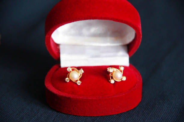 gold earrings with white pearls and diamonds in  red box