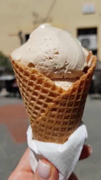 istock ice cream in a waffle cup in hand 1413779782