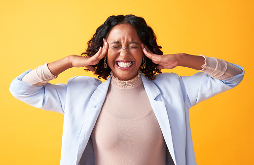 Excited, happy and ecstatic business woman holding her head and smiling against a colorful background. Thrilled female entrepreneur having mind blowing idea, feeling joyful about amazing opportunity