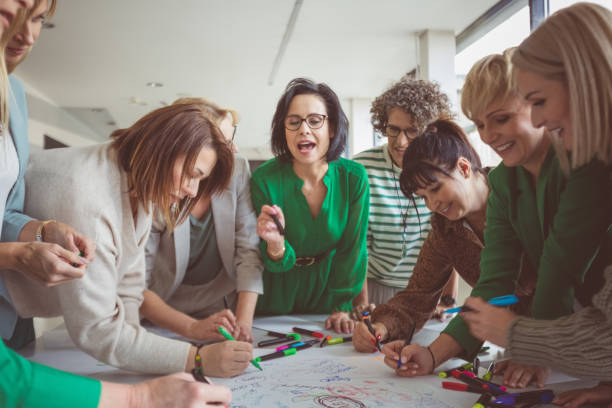 istock Businesswoman talking to colleagues sharing ideas 1413787741
