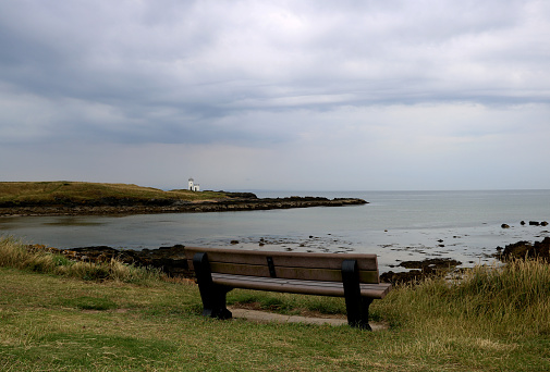 Public bench seat overlooking small lighthouse in Elie in Fife Scotland