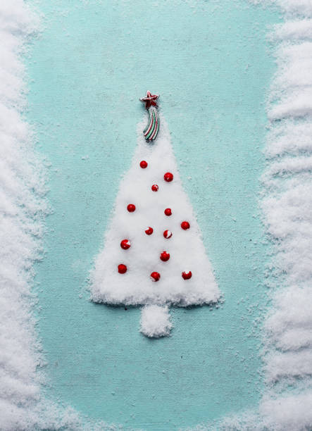 Christmas tree made with snow on blue background, top view. Minimal holiday concept