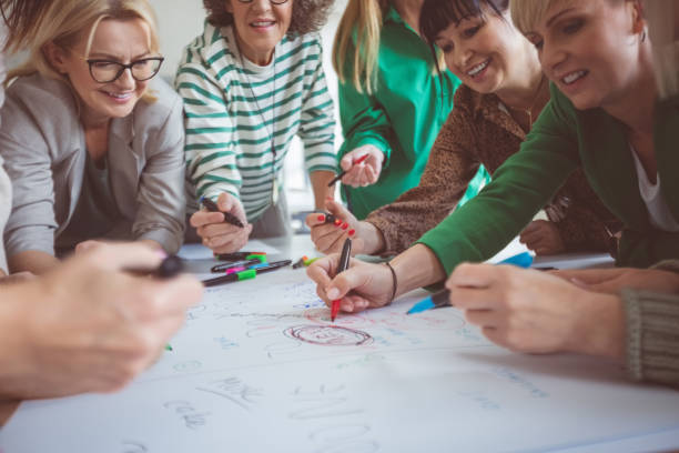 istock Colleagues writing with felt tip pens on paper 1413790000