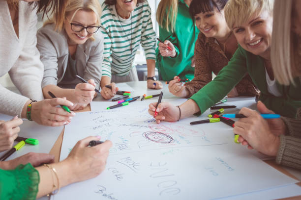 istock Happy colleagues sharing ideas on paper 1413792145