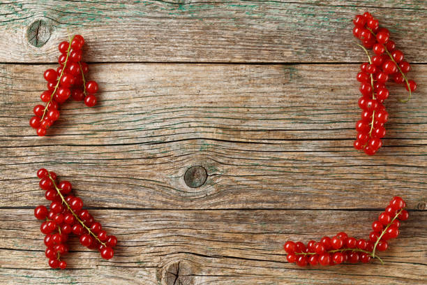 Fresh ripe red currants on old rustic wooden table. Frame for text. Copy space. Flat lay