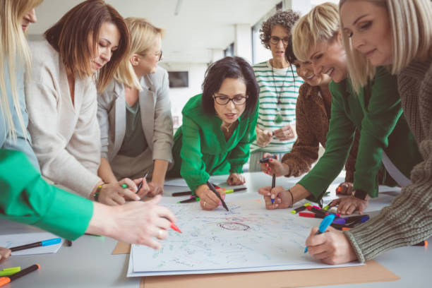 istock Mature female colleagues sharing ideas on paper 1413793873