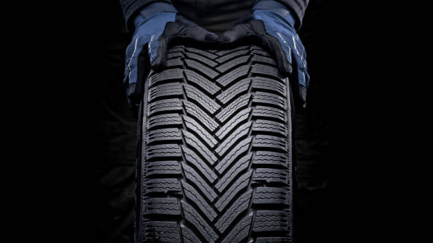 Man's hands pushing tyre stock photo