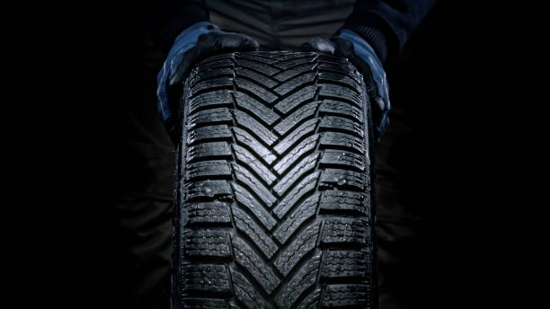 istock Man's hands pushing wet tyre 1413795233