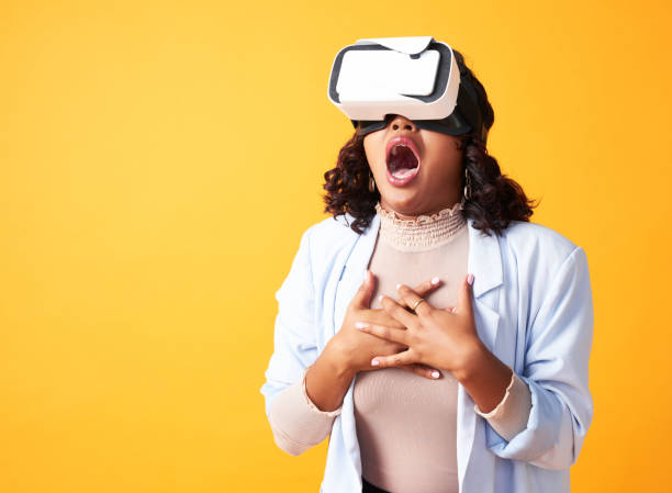 istock Watching metaverse, virtual reality and cyber world on vr goggles and looking surprised, shocked or amazed. Woman wearing 3D headset, gasping with mouth open or in awe on yellow copy space background 1413796993