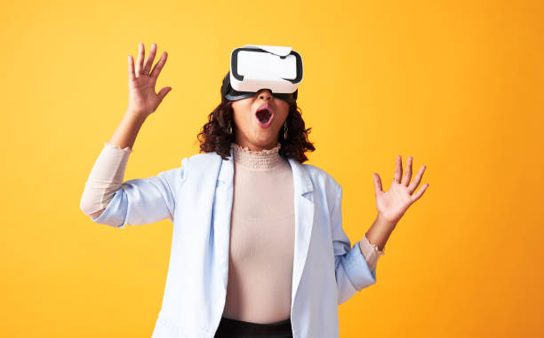 istock Innovation, futuristic and modern technology for virtual reality headset on woman alone in yellow studio. Female wearing a vr device to play a game, have fun and enjoy new wireless experience 1413797025