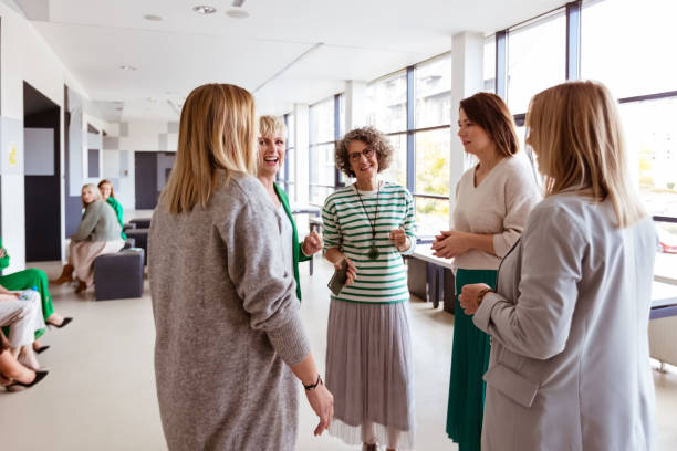 istock Businesswomen discussing while standing in office 1413798571