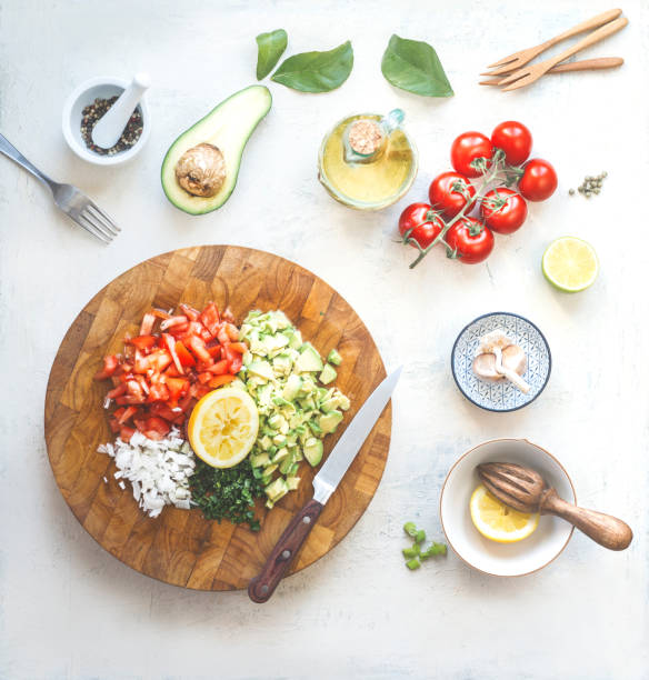 istock Chopped ingredients for avocado salsa, guacamole  or salad on cutting board. 1413799288