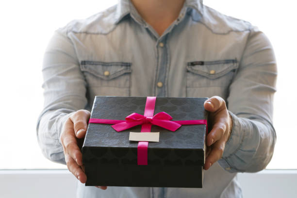 istock A man gives a gift in a box in hands 1413800096