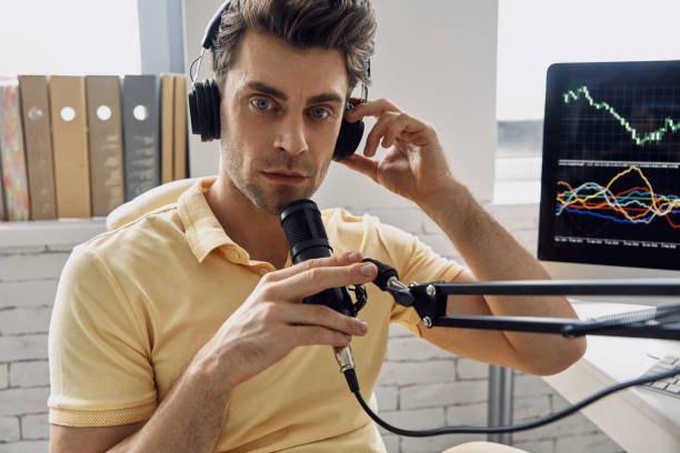 istock Confident man in headphones using microphone while recording his business podcast 1413800169