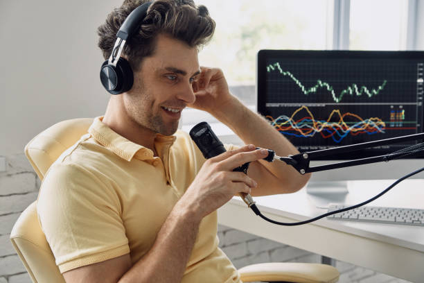 istock Cheerful man in headphones using microphone while recording his business podcast 1413800171