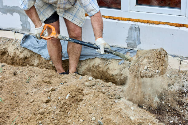 istock Digging trench for laying cable, construction worker uses shovel to take out soil. 1413801503