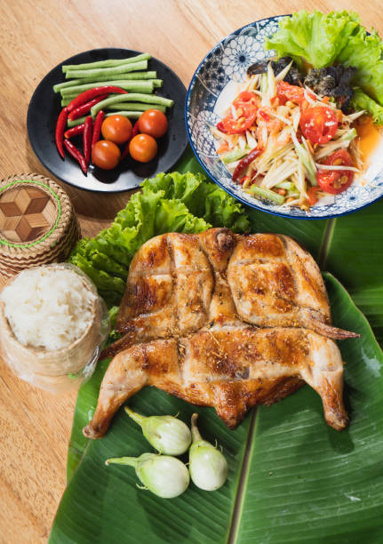papaya salad,grilled chicken with Steamed Sticky Rice and vegetables on banana leaves