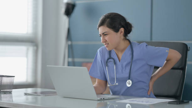 istock Indian Female Doctor having Back Pain while using Laptop in Office 1413802002