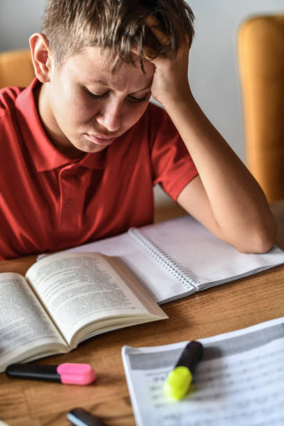 istock Male Child Staring At Book And Trying To Study While Getting First Myopia Symptoms 1413802216