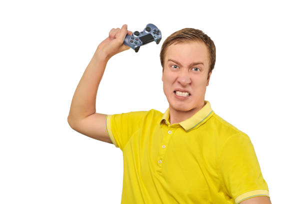 jogador irritado com gamepad sem fio vestido com camiseta amarela isolada em fundo branco - aggression control clothing image type - fotografias e filmes do acervo