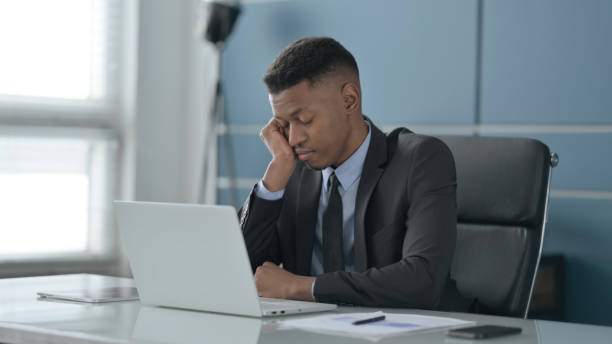 istock African Businessman taking Nap While Sitting in Office with Laptop 1413802313