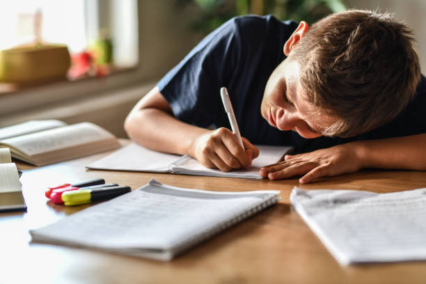istock Male Child Writing Down Letters Slowly And Getting Lower To See Them Due To Myopia 1413802577