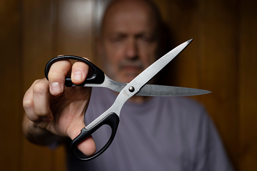 a man while making the gesture of cutting with scissors