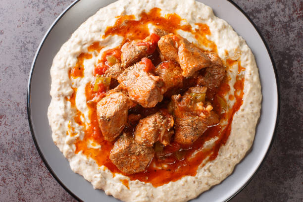 Sultan's Delight or Hunkar Begendi Lamb ragout with pureed eggplant and béchamel sauce closeup in the plate. Horizontal top view Sultan's Delight or Hunkar Begendi Lamb ragout with pureed eggplant and béchamel sauce closeup in the plate on the table. Horizontal top view from above hunkar begendi stock pictures, royalty-free photos & images