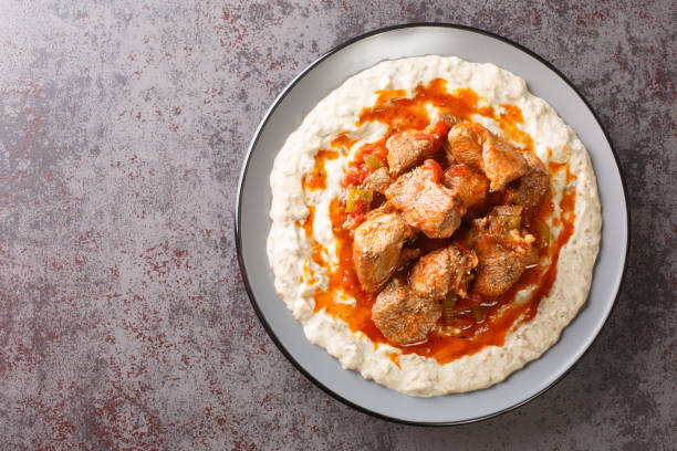 Turkish Food Hunkar Begendi made with Eggplant and Meat closeup in the plate. Horizontal top view Turkish Food Hunkar Begendi made with Eggplant and Meat closeup in the plate on the table. Horizontal top view from above hunkar begendi stock pictures, royalty-free photos & images