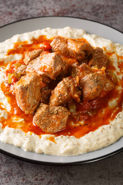 Sultan’s delight Hunkar begendi is an Ottaman dish that consists of a lamb stew served over an eggplant bechamel sauce closeup in the plate. Vertical Sultan’s delight Hunkar begendi is an Ottaman dish that consists of a lamb stew served over an eggplant bechamel sauce closeup in the plate on the table. Vertical hunkar begendi stock pictures, royalty-free photos & images