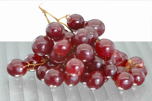Close-up of a bunch of red grapes in a black background. Freshness and washed fruit.