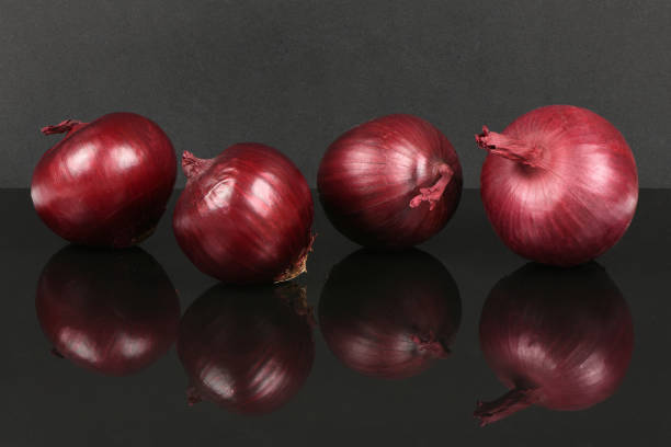 Red onion bulb isolated on acrylic black background. High resolution photo. Full depth of field.