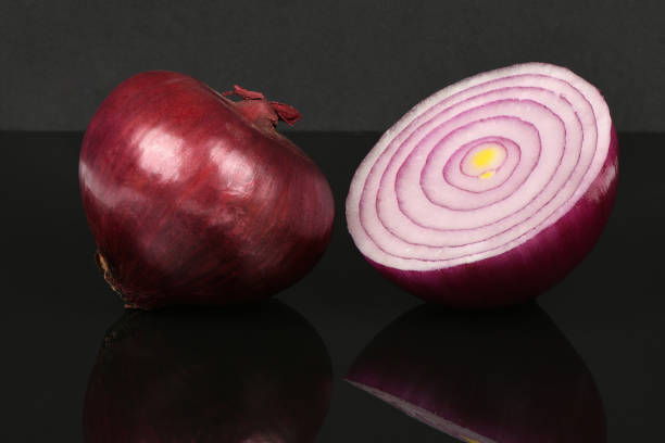 Red onion bulb isolated on acrylic black background. High resolution photo. Full depth of field.