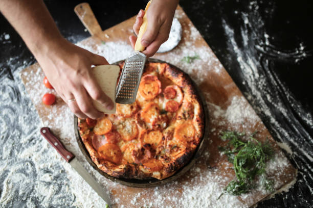 istock male hands rubbed cheese grated on pizza in home 1413812381