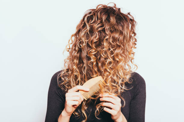 istock Woman combing her naturally curly hair 1413813337