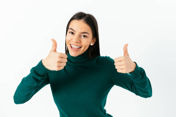 istock Cheerful young woman giving thumbs up with both hands 1413813372