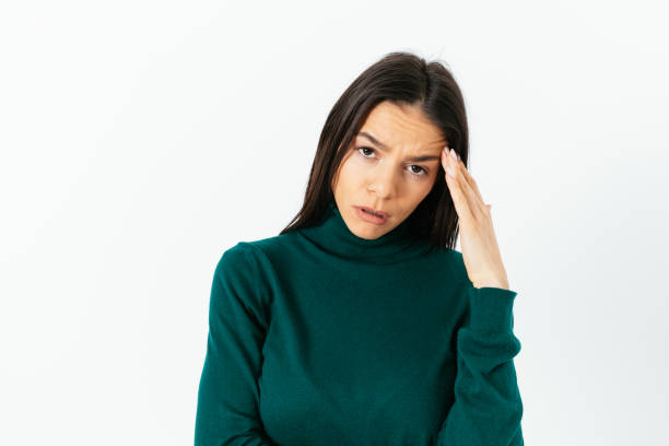 istock Frustrated exhausted young woman touches head with hand 1413813389
