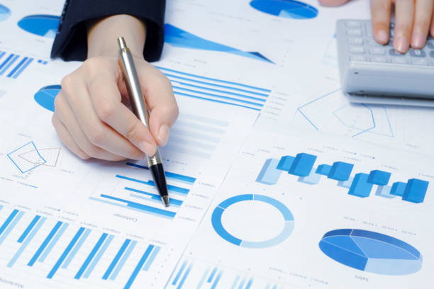 istock Businessman holding a profitability statistics analysis pen from a graph document in hand  to plan profit. 1413814352