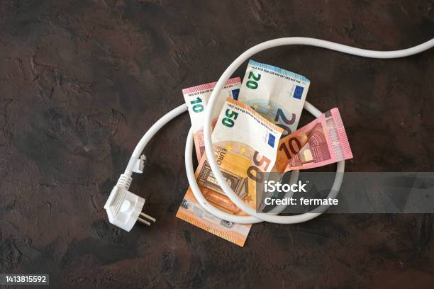 Bundle Of Euro Banknotes Tied Up With An Electric Power Cable With Plug Concept For Energy Efficiency Power Consumption And Rising Electricity Costs Dark Background Copy Space Stock Photo - Download Image Now