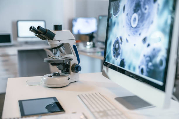 adn, arn o patología de un virus que se muestra en una pantalla de computadora o monitor en un laboratorio moderno o instalación de investigación. un microscopio científico en un escritorio para análisis, experimentos y ensayos clínicos - microscope laboratory science research fotografías e imágenes de stock