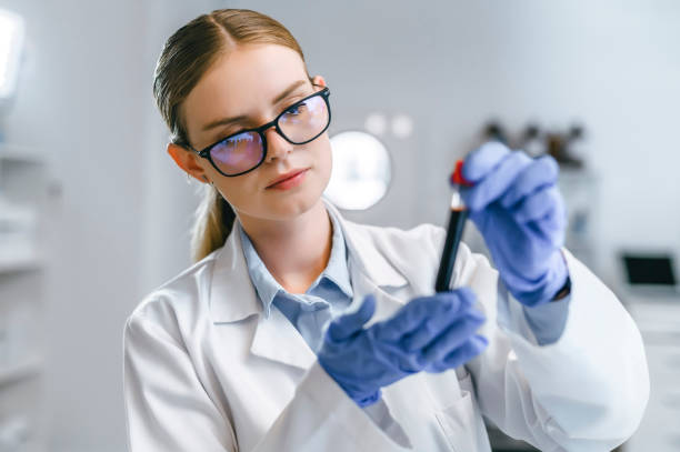 istock Smart looking scientist working with blood sample, DNA testing, or virus research in a modern lab. One female science or biology intern analyzing test tube for disease or drug use in a laboratory 1413817364