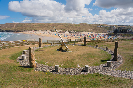 The sun shines down on the Perranporth Sundial and beach in Cornwall.