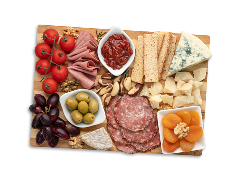 Appetizer board with cheese, nuts, fruits, toasts and charcuterie isolated over white background.