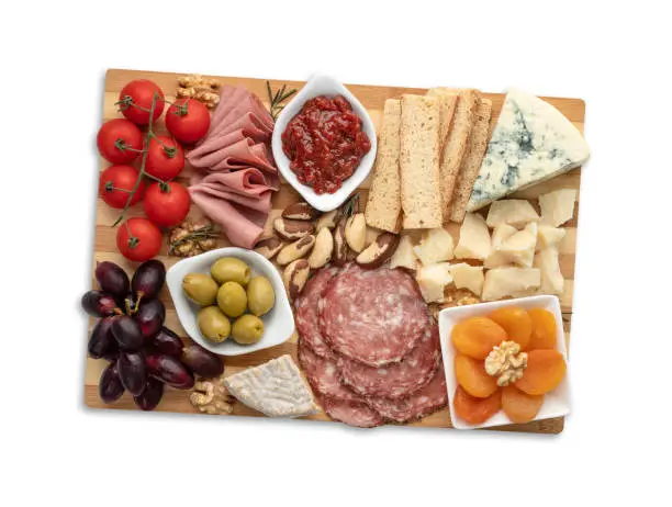 Appetizer board with cheese, nuts, fruits, toasts and charcuterie isolated over white background.